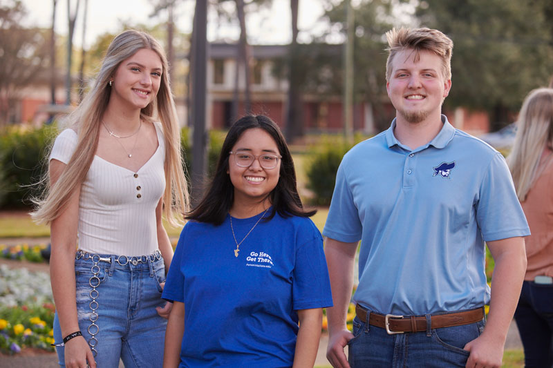 Decorative image of three PSC students pictured smiling together