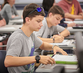 Decorative image of PSC students working at their desks in the classroom